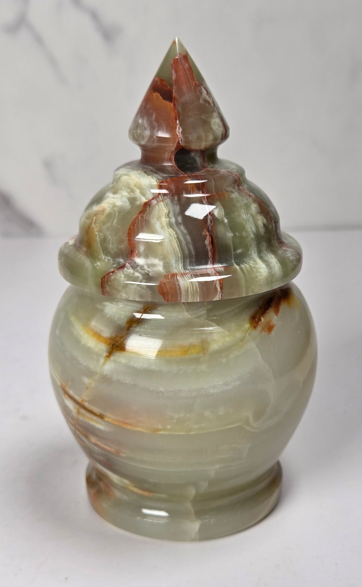 banded calcite candy jars with green, brown and red banding against a marbled background