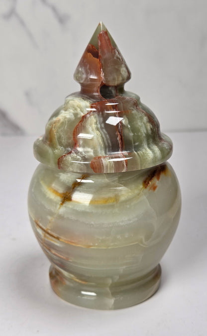banded calcite candy jars with green, brown and red banding against a marbled background