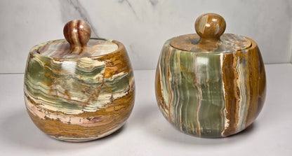 banded calcite jars with green, brown and red banding against a marbled background