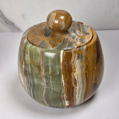 banded calcite jars with green, brown and red banding against a marbled background
