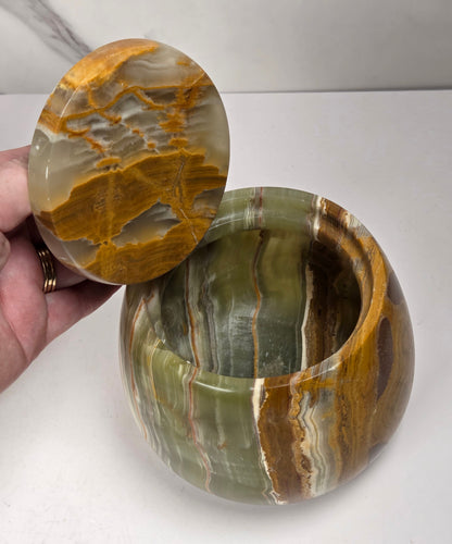 banded calcite jars with green, brown and red banding against a marbled background