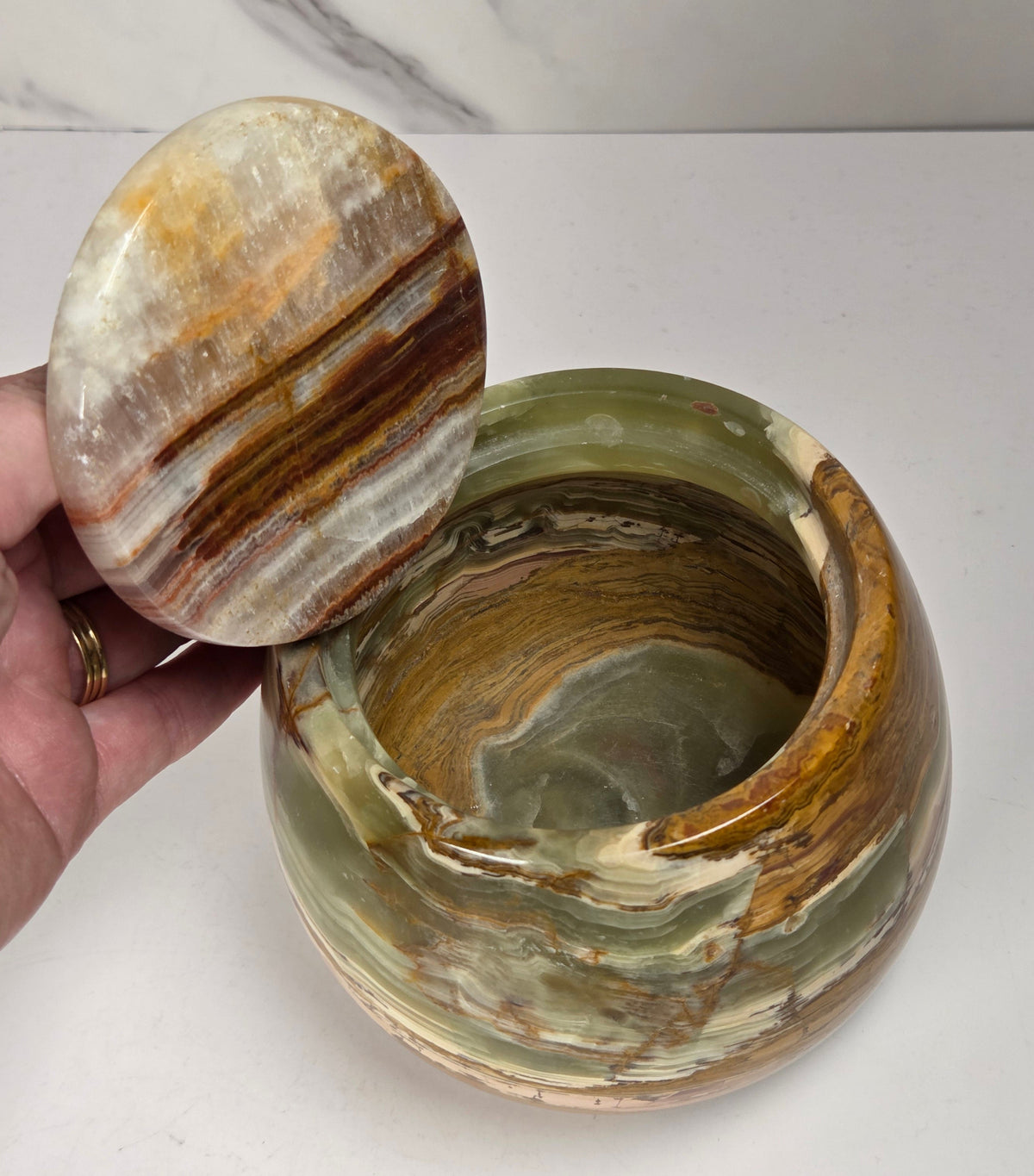 banded calcite jars with green, brown and red banding against a marbled background